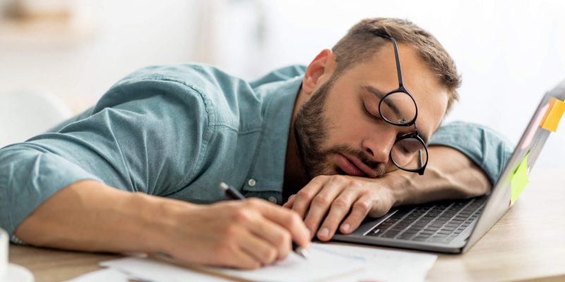 Man-napping-at-work-desk-scaled.jpeg